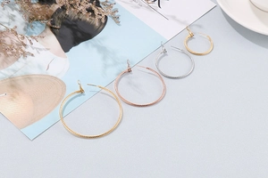 Detail of twisted rope texture round earrings in gold rose gold and silver finishes