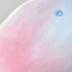 Macro shot of breathable eyelet on tie-dye cotton fabric of a gradient sun hat