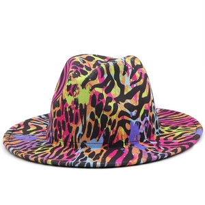 Close-up of vibrant neon rainbow pattern with black zebra stripes on a wool felt fedora hat