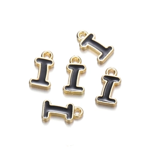 Detail shot of five golden metal letter I pendants with black enamel finish on white background