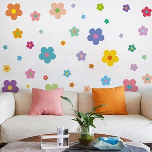 Colorful cartoon flower wall decals in a modern living room setting with sofa and plant
