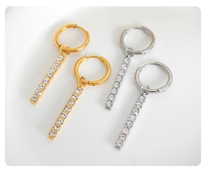 Dettaglio di orecchini pendenti in oro e argento con pavé di zirconi luminosi