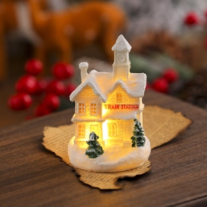 Detailed view of glowing white resin Christmas train station with warm LED light