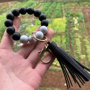 Detail of colorful silicone bead bracelet with gold lobster clasp and black PU tassel