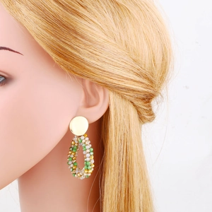 Detail of bohemian geometric drop earrings with colorful crystal beads on a model