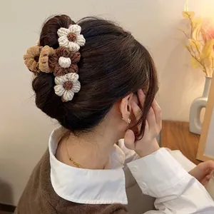 Handcrafted woven flower hair claw clip with autumn brown and cream knit floral accents