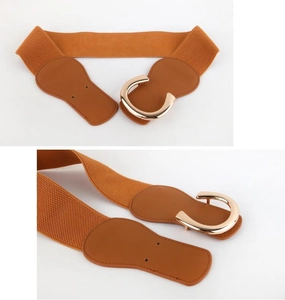 Detail of orange-brown elastic belt with gold C-buckle and textured leather ends