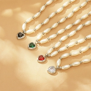 Detail of four faux pearl necklaces with colorful heart-shaped crystal glass pendants