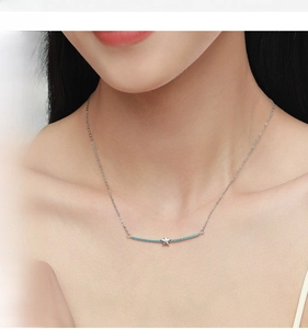 Detail of S925 sterling silver star necklace with blue gemstone on model neck