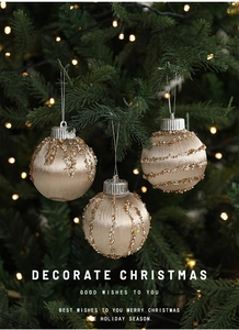 Detailed view of champagne silk ornaments with golden beads on a lit Christmas tree