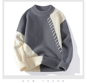 Detail eines Farbblock-Strickpullovers mit handgenähten Nähten in Dunkelgrau und Beige