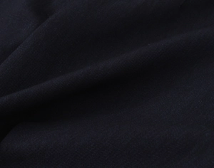 Macro shot of navy blue blazer fabric showing high-density twill weave texture