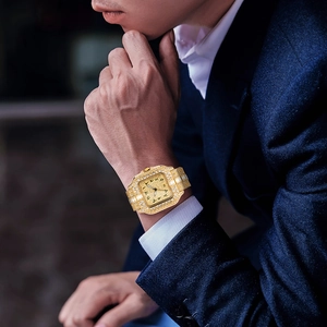 Close-up of a luxury gold square men's watch fully iced out with diamonds on a wrist
