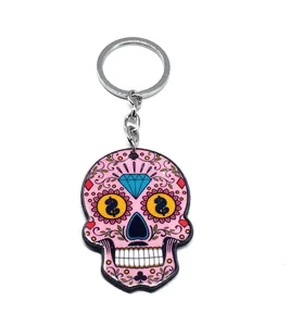 Macro detail of pink sugar skull acrylic keychain with floral patterns and gold accents