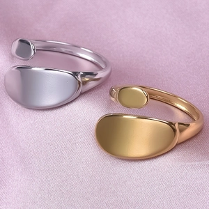 Macro view of gold and silver minimalist wavy rings on lavender silk textured fabric