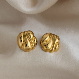 Gros plan de boucles d'oreilles rondes plaquées or 18K avec texture ondulée irrégulière