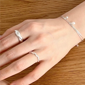 Detail of 925 sterling silver set featuring twisted ring and thin beaded bracelet