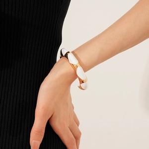 Detail of vintage French oval open bangle with gold metal and white enamel inlay