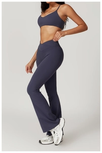 Detail of high-waist crossover yoga flare pants and strappy sports bra in deep blue