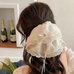 Elegant white lace bow hair scrunchie with embroidery and bead detail shown on hair