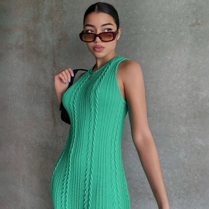 Primer plano de vestido sin mangas de punto verde que muestra la textura trenzada