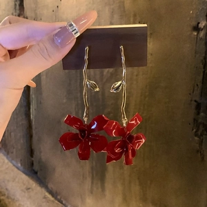 Elegant gold-tone long drop earrings with red flower pendants and metallic finish