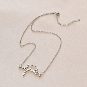 Detailed view of silver heart and heartbeat pendant on a titanium steel necklace
