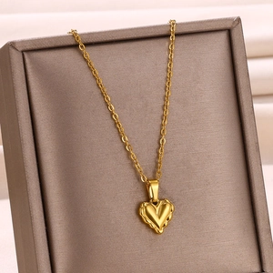 Détail du collier avec pendentif cœur plaqué or 18k et chaîne en O sur un support élégant
