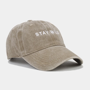 Close-up of khaki washed cotton baseball cap with STAY WILD embroidery on white background