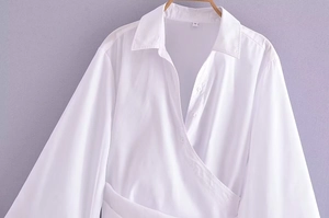 Détail de l'encolure d'une chemise cache-cœur blanche avec étiquette de taille S