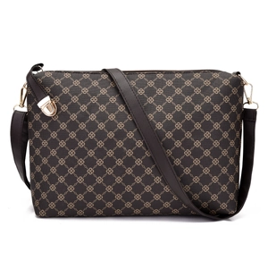 Detail of crossbody bag featuring printed chain pattern and golden metal turn-lock