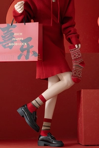 Détail de chaussettes en laine épaisses avec flocons nordiques et rayures rouges tricot