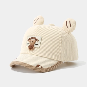 Detail of corduroy texture and 3D bear ears on a cream baby baseball cap with patches