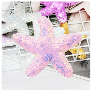 Close-up of sparkling sequin starfish hair clips in pink and pastel colors on white grid