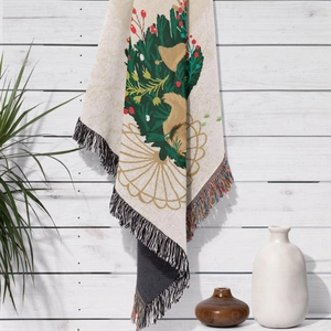 Close-up of woven Christmas blanket with bell pattern and decorative fringe tassels