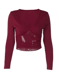 Détail d'un crop top bordeaux à manches longues avec décolleté en V et empiècement en résille