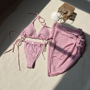 Macro detail of pink textured fabric three-piece bikini set with matching beach skirt