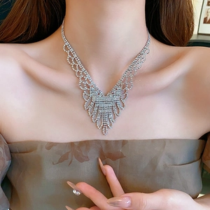 Close-up of elegant V-shaped layered silver necklace with rhinestones on model neck