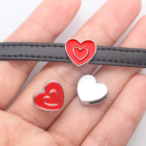 Macro view of a red heart enamel charm slider for 8mm leather wristbands and DIY bracelets
