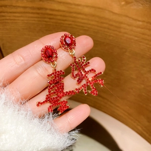 Detail of red rhinestone Chinese 'Xi' character earrings in gold finish with diamonds
