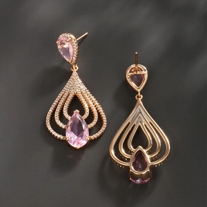 Detailed macro view of rose gold drop earrings with pear-cut pink stones and cubic zirconia