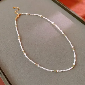 Elegant beaded necklace with white shell pearls, green stones and gold spacers
