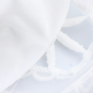 Robe blanche style français avec broderie florale, manches bouffantes et détails dentelle