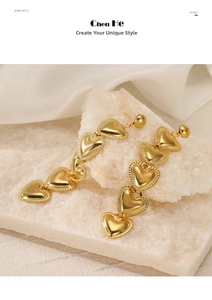 Detailed view of long gold drop earrings with five linked heart pendants and beaded edges