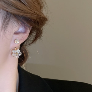 Detail of flower stud earring with sparkling crystals on female model in profile view