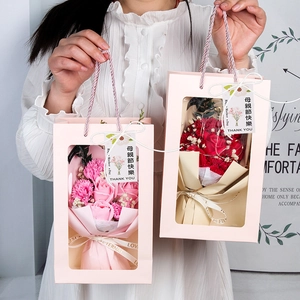 Detail of pink carnation soap flower bouquet in window gift bag with fairy lights