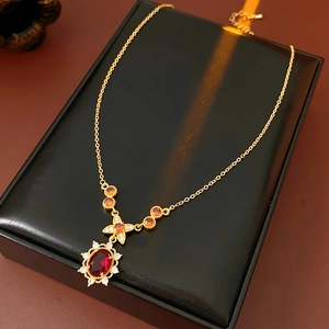 Detailaufnahme der goldenen Vintage-Halskette mit ovalem rotem Edelstein und Zirkonia