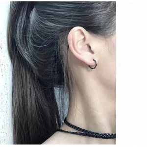 Detail of black twisted rope hoop earrings and leather necklace on a model's profile