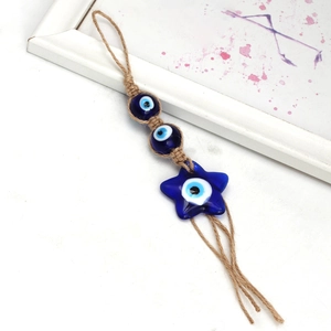 Detail of handmade evil eye charm with blue glass star and beads on braided hemp rope