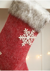 Close-up of red felt Christmas stocking with plush trim and white snowflake applique